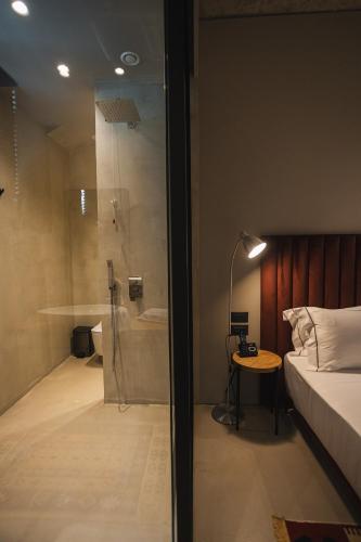 a bedroom with a shower and a bed and a table at Dot Tradition in Vlorë