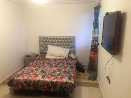- une chambre avec un lit et une télévision à écran plat dans l'établissement بساتين كليز, à Marrakech