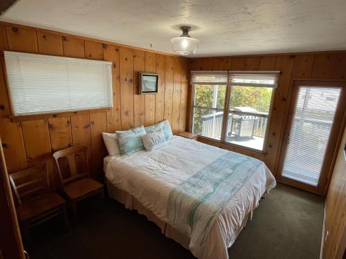 a bedroom with a bed in a room with wooden walls at 141 A 1st Street in Avila Beach