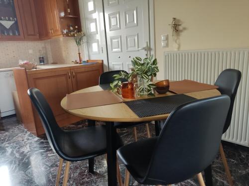 a kitchen with a wooden table with chairs and a table at Village House with view in Poullakídha