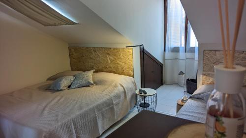 um quarto com uma cama e uma grande janela em Loft64 em Alba