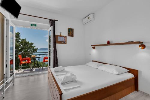 a bedroom with a bed and a balcony with a view at View Blue Apartments in Brela