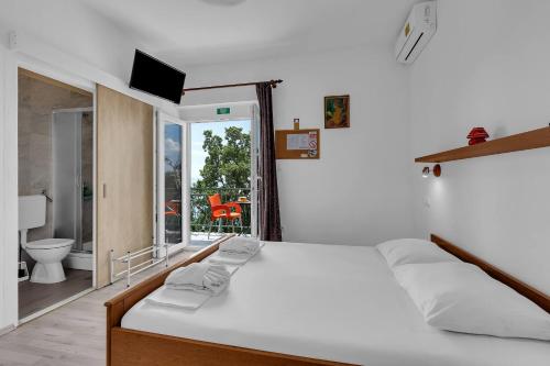 a bedroom with a bed and a view of a bathroom at View Blue Apartments in Brela
