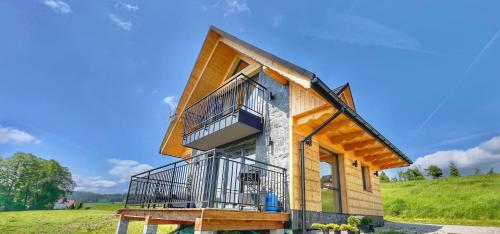 Cette maison est entourée d'une terrasse couverte et d'un balcon. dans l'établissement Tatra Village, à PyzÃ³wka