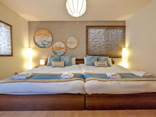1 dormitorio con 1 cama grande con almohadas azules en Tsukiyume Kan - House with Parking, 10Mins to USJ, Tennoji, Namba en Osaka