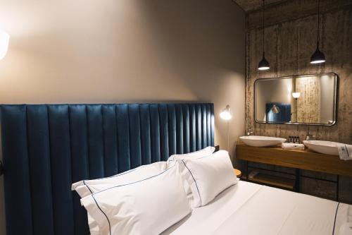 a bedroom with a bed and a sink and a mirror at Dot Tradition in Vlorë