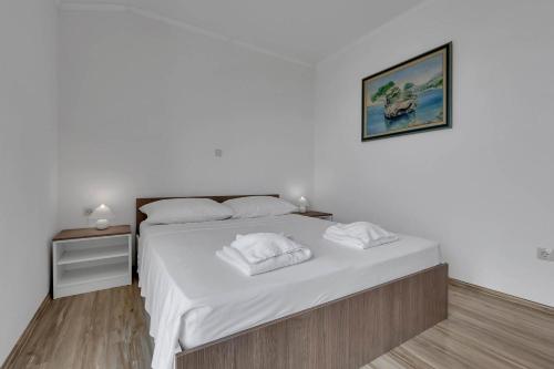 a white bed with two towels on top of it at View Blue Apartments in Brela