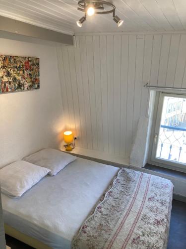 une chambre avec un lit avec une lampe et une fenêtre dans l'établissement Centre médiéval Sarlat, à Sarlat-la-Canéda