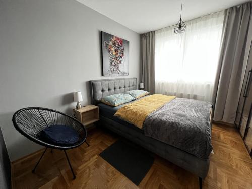 1 dormitorio con 1 cama, 1 silla y 1 ventana en Apartment 4 two / 1 + EV Charger + Private parking, en Zagreb