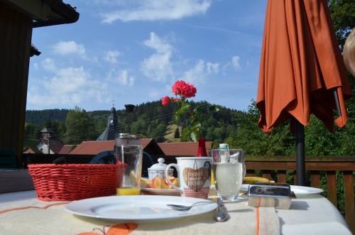 una mesa con un plato de comida y una sombrilla en Ferienhaus Am Sommerberg, en Gießübel