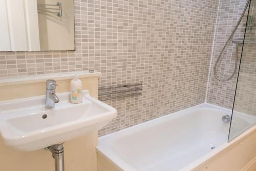 a bathroom with a sink and a bath tub at York Terrace Apartments - Norwich City in Norwich
