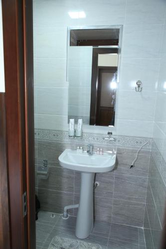 a bathroom with a white sink and a mirror at HOTEL MEHRIBON in Samarkand