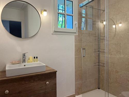 a bathroom with a sink and a shower with a mirror at Les Stoechades in Rayol-Canadel-sur-Mer