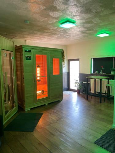ein leeres Zimmer mit einer grünen und orangefarbenen Maschine in der Unterkunft Casawellness améthyste ou jaspe océan avec jacuzzi intérieur in Floreffe