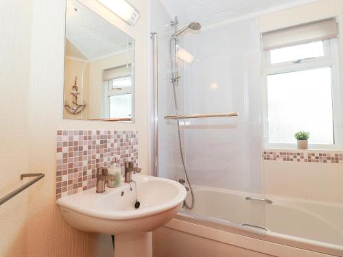 a white bathroom with a sink and a shower at Nutkins Lodge in Windermere