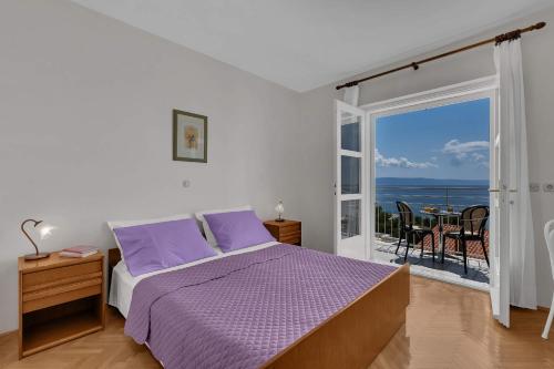 um quarto com uma cama e vista para o oceano em Beachfront Rooms Ana em Tučepi