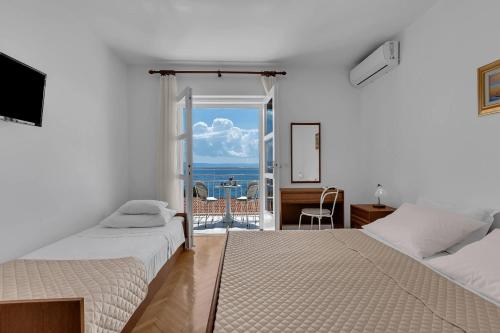 a bedroom with two beds and a view of the ocean at Beachfront Rooms Ana in Tučepi