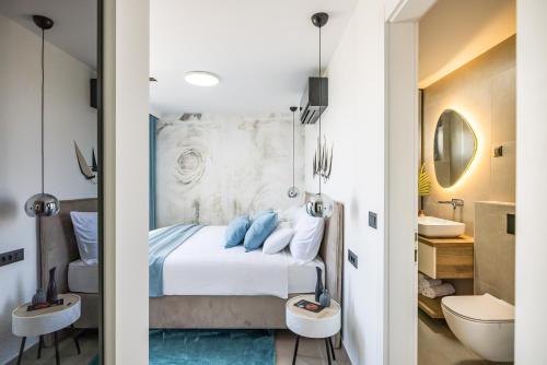 a bedroom with a bed and a bathroom with a sink at Villa Corus in Murter