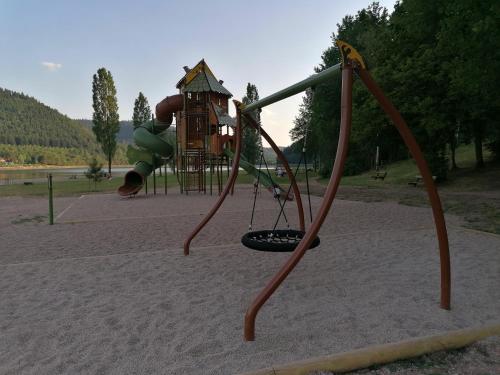 a child playing on a swing set at a playground at gîte de rarounette au cœur des Vosges in Celles-sur-Plaine