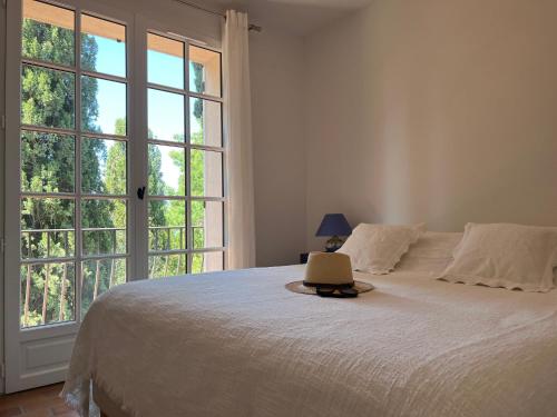 a bedroom with a bed and a large window at Les Stoechades in Rayol-Canadel-sur-Mer