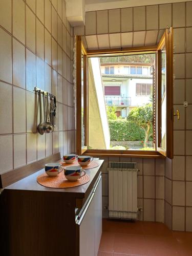 a kitchen with two bowls on a counter with a window at Appartamenti Portiglioni-Cipressi in Puntone di Scarlino