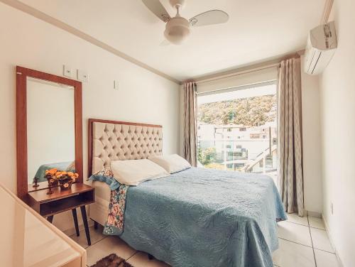 - une chambre avec un lit, un miroir et une fenêtre dans l'établissement Hospedagem Stein - Apartamento 201, à Domingos Martins