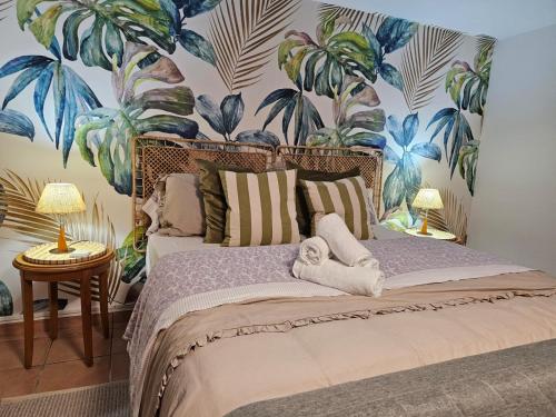 a bedroom with a bed with a mural of palm trees at Villa Mogaren in Vega de San Mateo