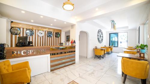 a restaurant with yellow chairs and a counter at My Home Hotel Gulluk in Antalya