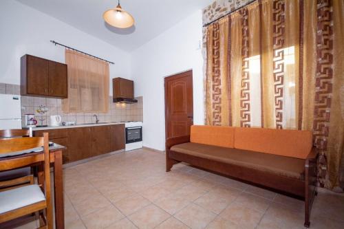 uma cozinha com um banco no meio de uma sala em Christina Apartments em Kissamos