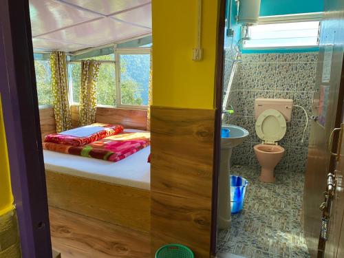 ガントクにあるLamakhang Homestayのベッドとトイレのある小さな寝室