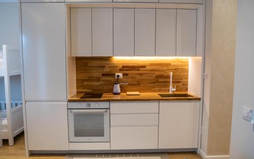 a kitchen with white cabinets and a stove top oven at Sense Luxury Apartments in Velipojë