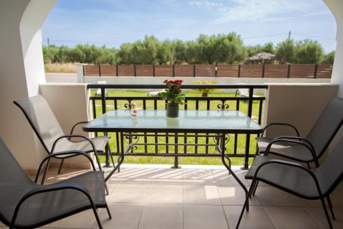 a patio with a table and chairs on a balcony at Tropical Apartments in Alykes