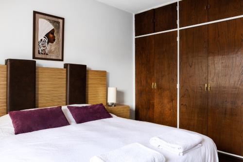 een slaapkamer met een groot wit bed en houten kasten bij Piso villegas in Bariloche