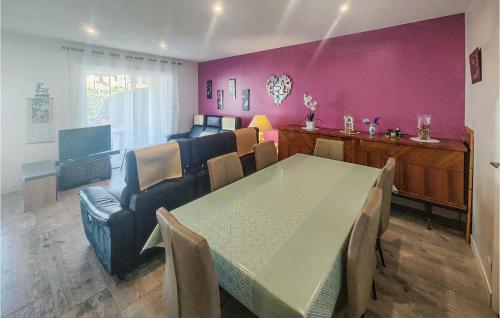 a dining room with a table and chairs and purple walls at 2 Bedroom Cozy Home In Portiragnes in Portiragnes