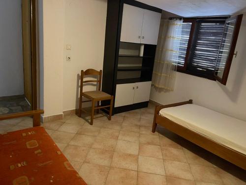 a bedroom with a bed and a chair and a table at Exohi apartments in Vrasná