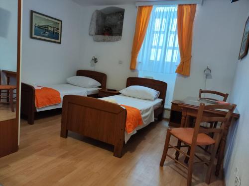 1 Schlafzimmer mit 2 Betten, einem Schreibtisch und einem Tisch in der Unterkunft Maja Apartments in Trogir