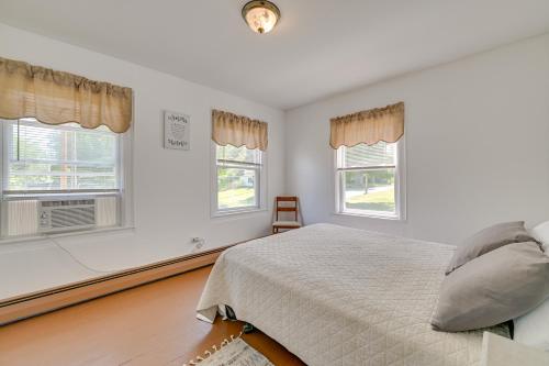 a white bedroom with a bed and two windows at Countryside Hideaway - 10 Mi to Cooperstown! in Westford