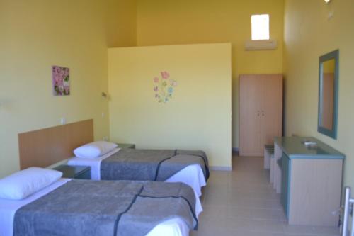 a hotel room with two beds and a sink at To Akrogiali in Phanaes