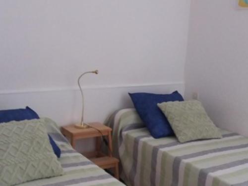 une chambre avec deux lits et une lampe sur une table dans l'établissement 1er étage, balcon, animaux admis, parking de proximité - FR-1-503-8, à Balaruc-les-Bains