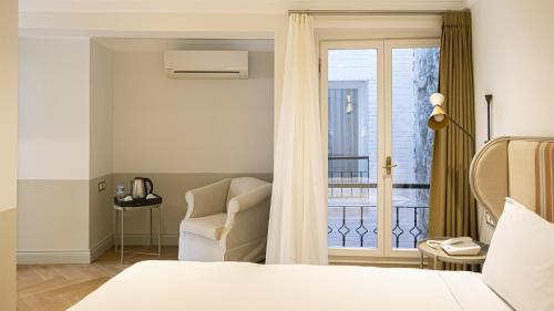 ein Schlafzimmer mit einem Bett, einem Stuhl und einem Fenster in der Unterkunft Ishak Pasa Palace by Signature Hotels in Istanbul