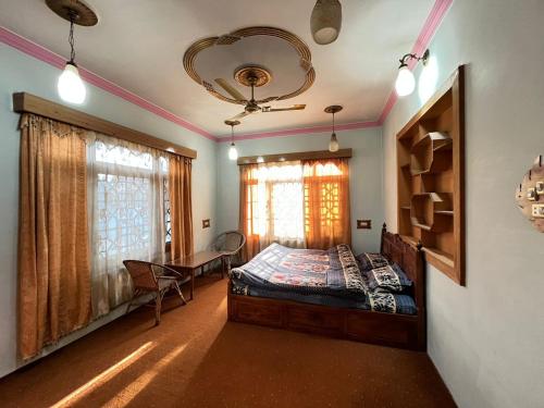 a bedroom with a bed and a table in it at Grand Inayat in Srinagar