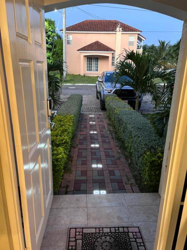 a door to a house with a brick walkway at Comfort Rest in Ocho Rios