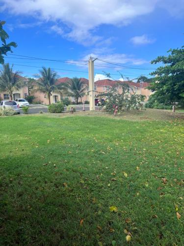 a field of green grass with buildings in the background at Comfort Rest in Ocho Rios