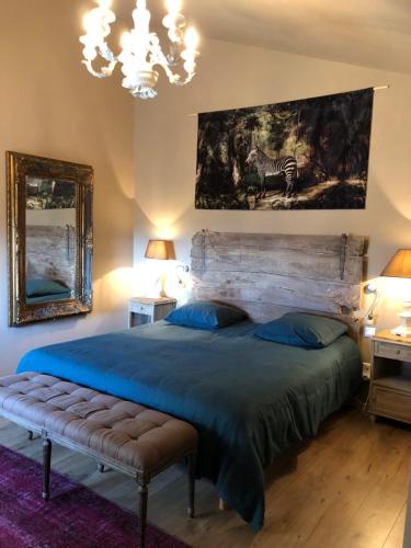 een slaapkamer met een groot bed en een groot schilderij aan de muur bij La Maiz in Maubec
