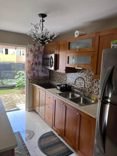 uma cozinha com armários de madeira e um lavatório em Comfort Rest em Ocho Rios