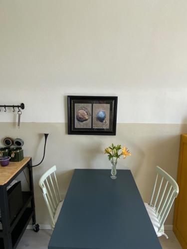 een eetkamer met een blauwe tafel en witte stoelen bij Het Pauzeerhuis in Middelburg