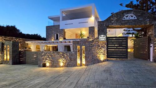 a house with a stone fence and a gate at Mykonos Double Luxury Mini Suites - Adults only in Ano Mera