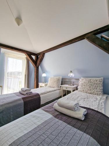 a bedroom with two beds and a large window at Szafranówka in Władysławowo