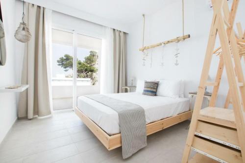 Habitación blanca con cama y escalera en Bella vista Suites en Kárpatos