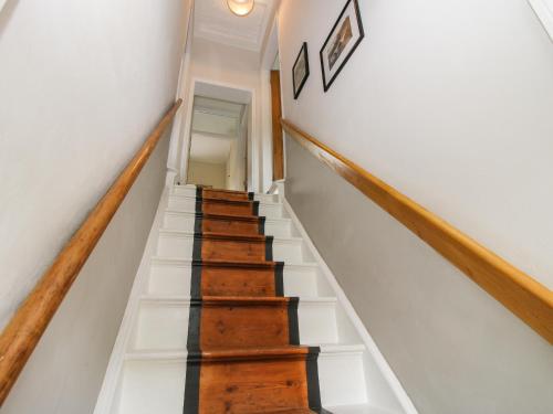 a staircase in a house with white walls and wooden floors at The Ferns in Ludlow
